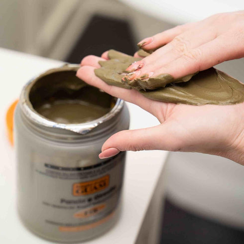 Scooping GUAM infrared seaweed mud body wrap out of the jar