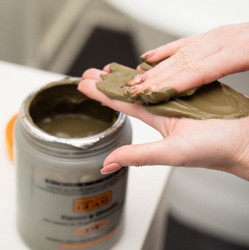 Scooping GUAM Turbo Toning infrared seaweed mud out of the jar