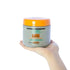 Hand holding GUAM Cold Formula de-puffing seaweed body wrap jar