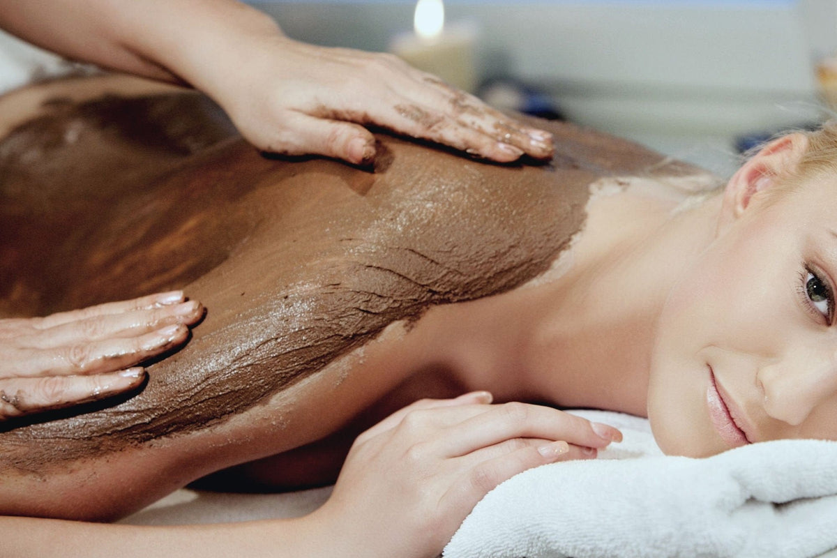 Woman relaxing during an infrared body wrap with seaweed mud on her back