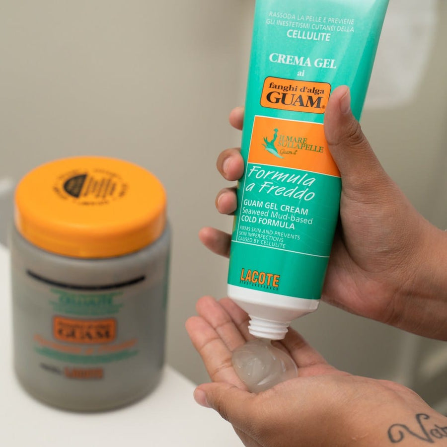 Hands holding GUAM Cold Formula body wrap mud and cooling gel