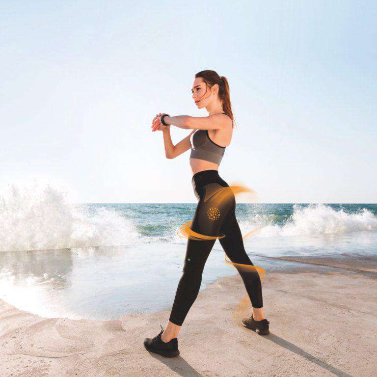 Woman exercising on a beach in GUAM anti-cellulite leggings with far infrared fabric