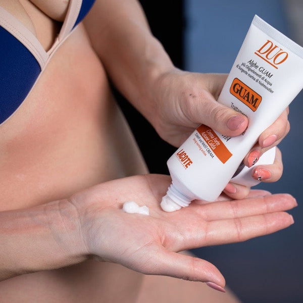 Squeezing GUAM Duo Slimming Tummy Cream into the palm for the waist after weight loss