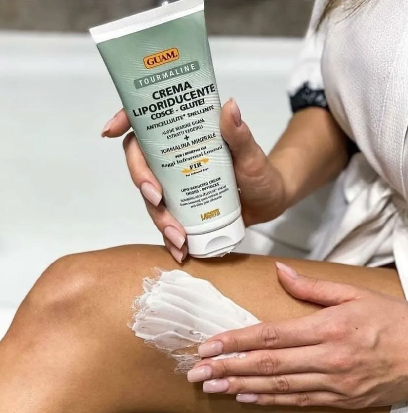 Hand massaging GUAM caffeine cream for cellulite into the thigh